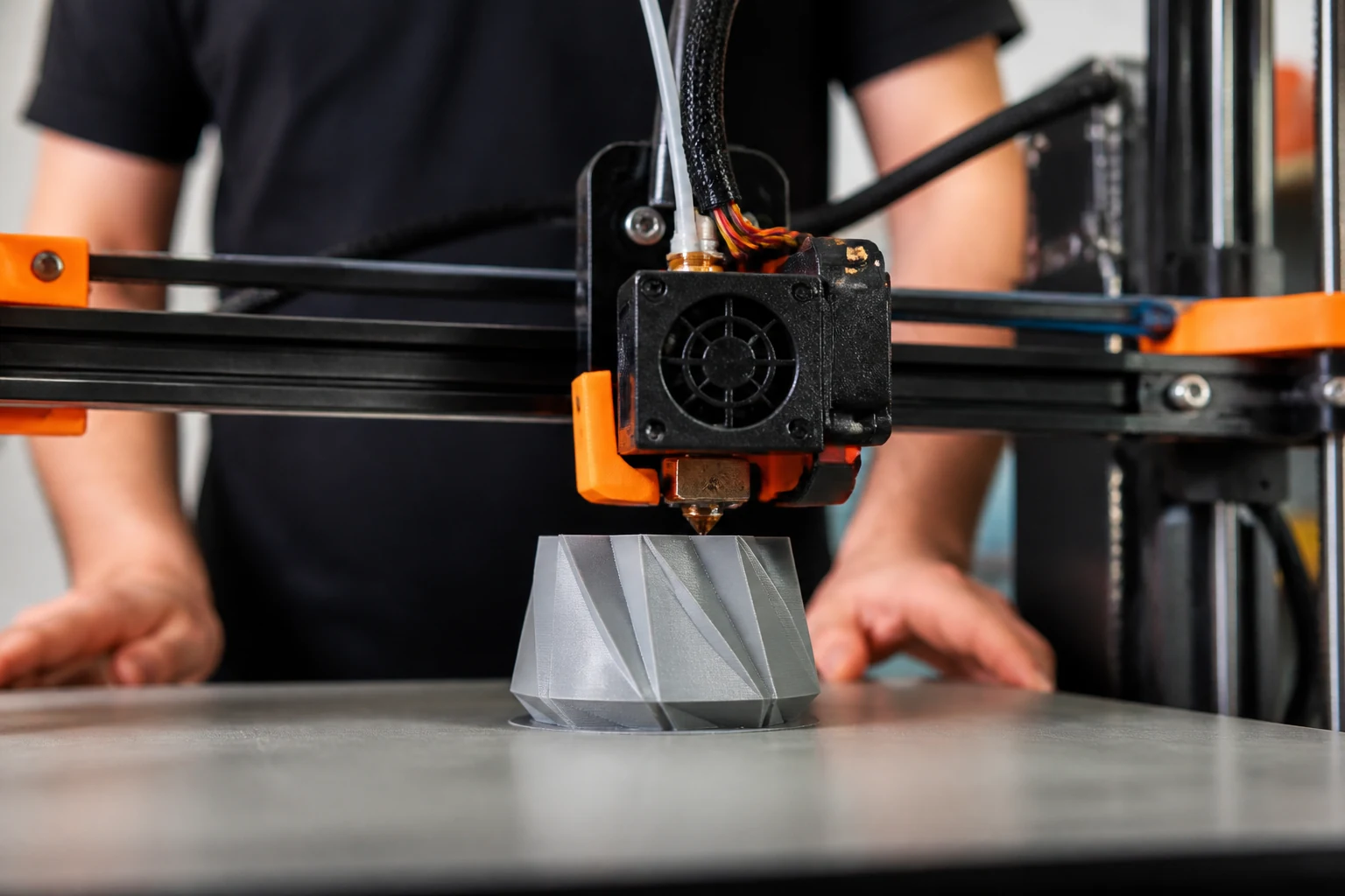 Une imprimante 3D construisant un objet en plastique couche par couche sur son plateau