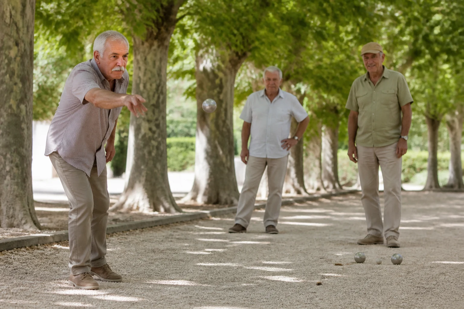 Joueurs disputant une partie de pétanque sur une place de village provençal