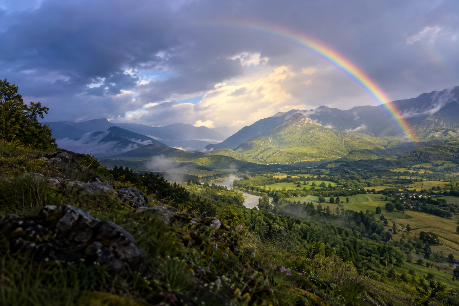 Arc-en-ciel au-dessus d'une vallée verdoyante après la pluie