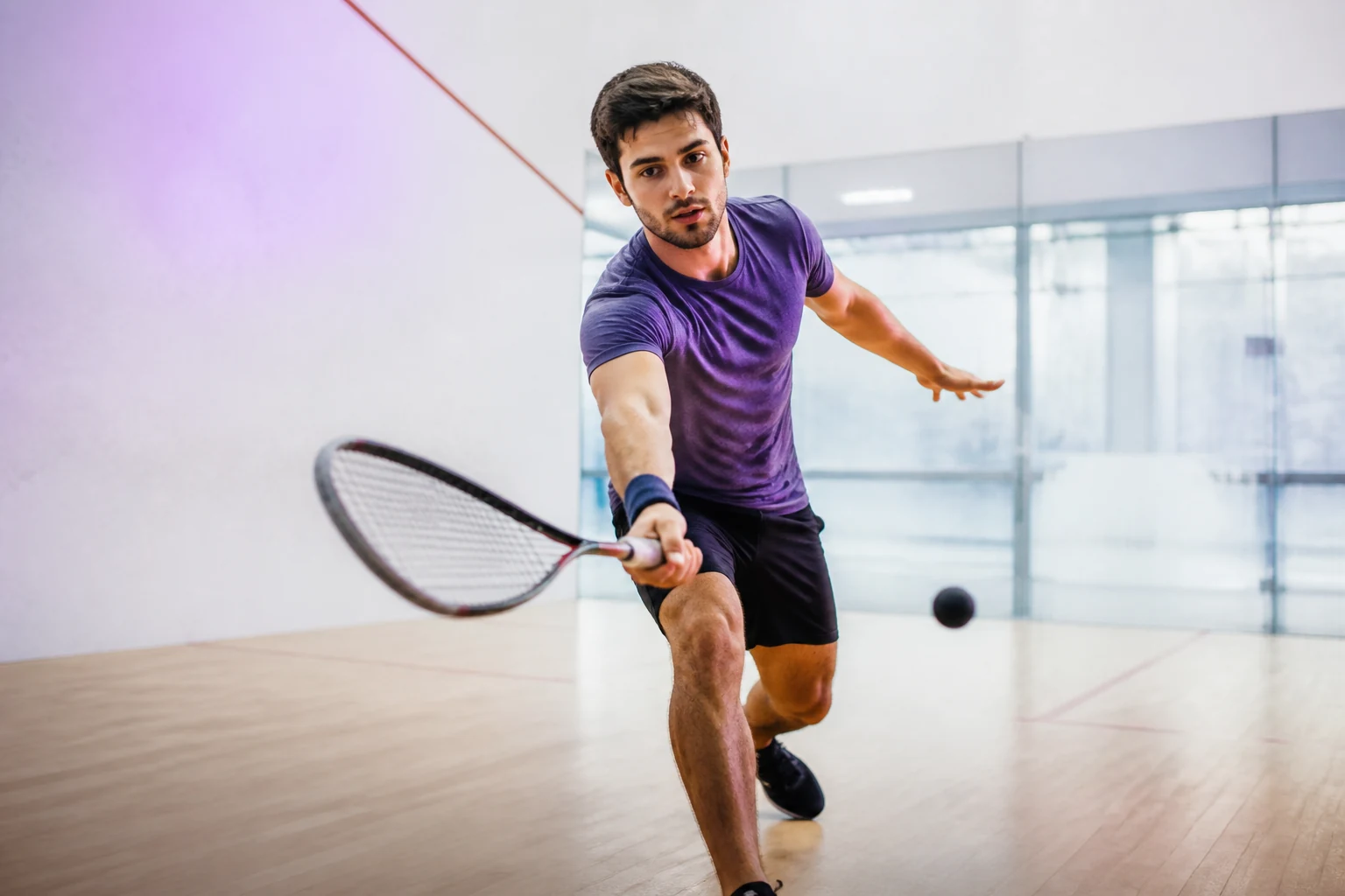 Deux joueurs de squash en plein échange sur un court fermé