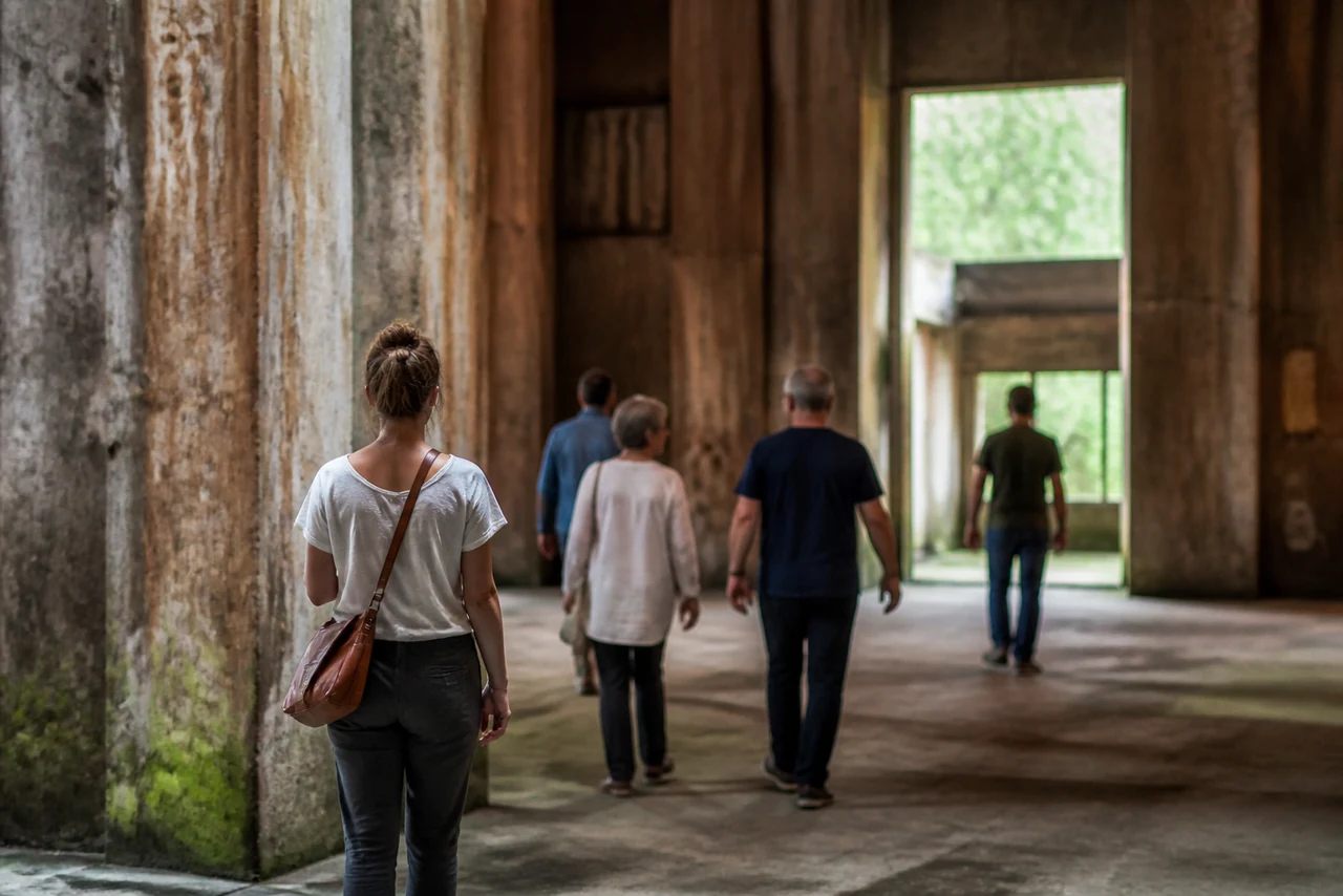 Visiteurs recueillis devant un mémorial associé au tourisme noir